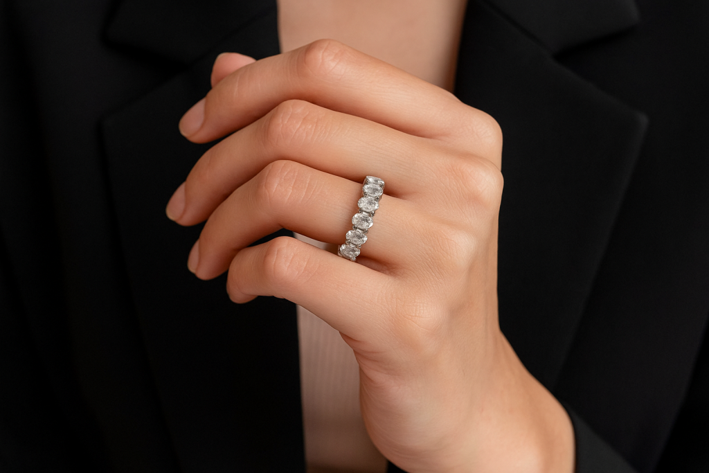 Ant moters rankos baltas auksinis žiedas su ovalo formos deimantais ratu – elegantiška deimantinė juostelė