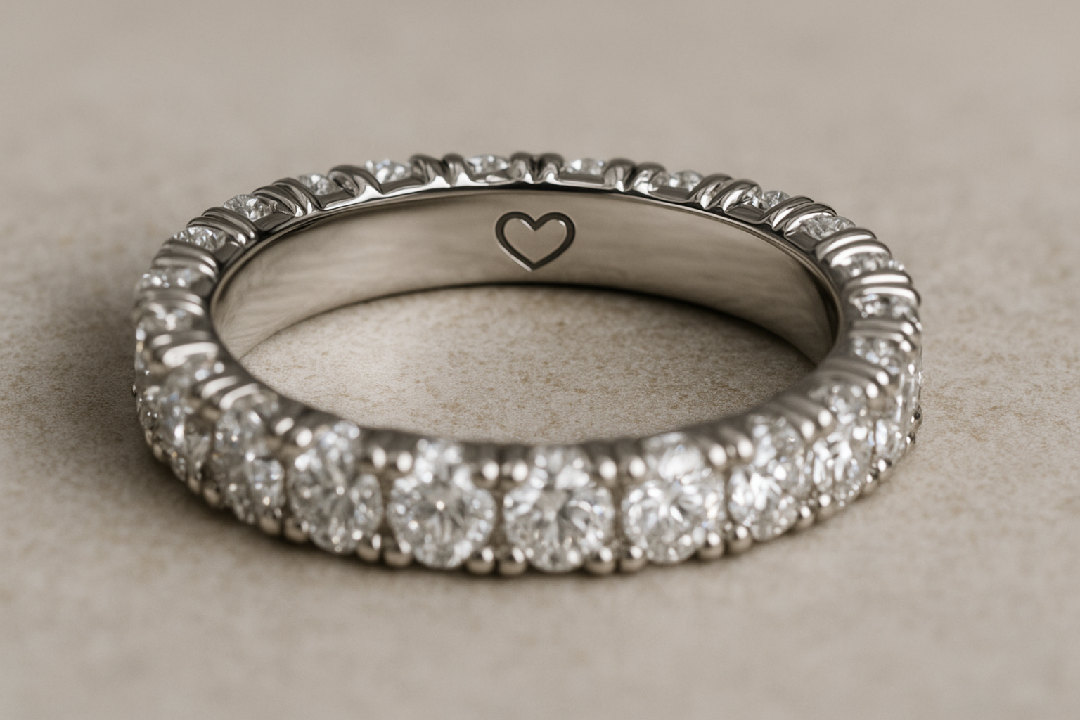 Deimantinė juostelė su briliantais ratu ir širdelės graviruote – populiari sužadėtuvių žiedų 2025 metų tendencija, simbolizuojanti meilę ir ištikimybę