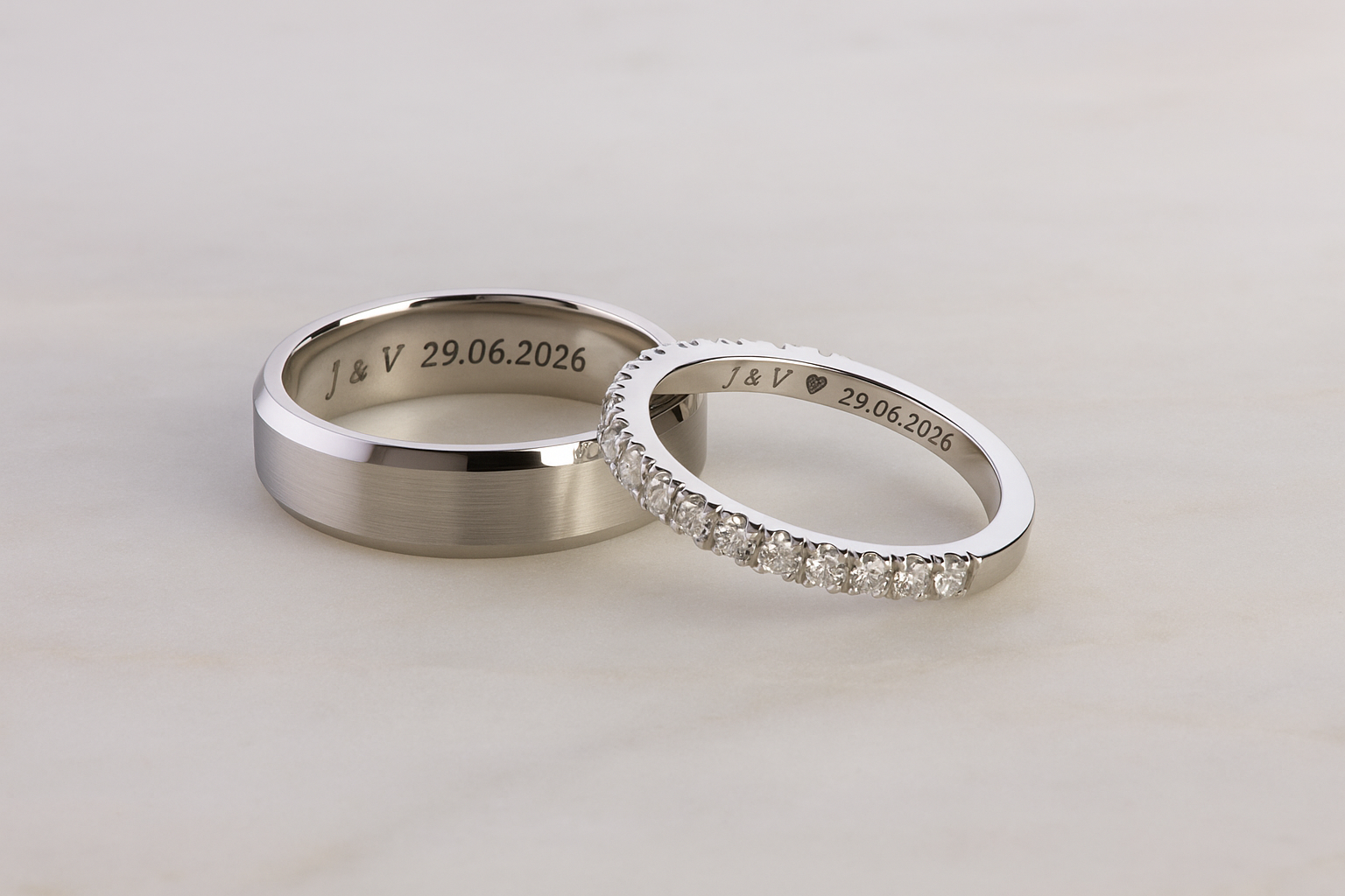 Vestuviniai žiedai su deimantais, spindintys švelnioje šviesoje
