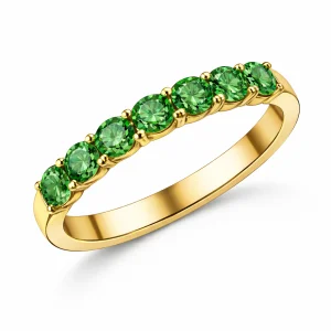 Žiedas juostelė iš geltono aukso su žaliais turmalinais, nešiojamas ant moters rankos, minimalistinis ir modernus įvaizdis