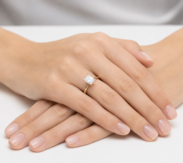 Geltono aukso sužadėtuvių žiedas su Emerald deimantu (Lab Grown 1.00 ct) ant merginos rankos