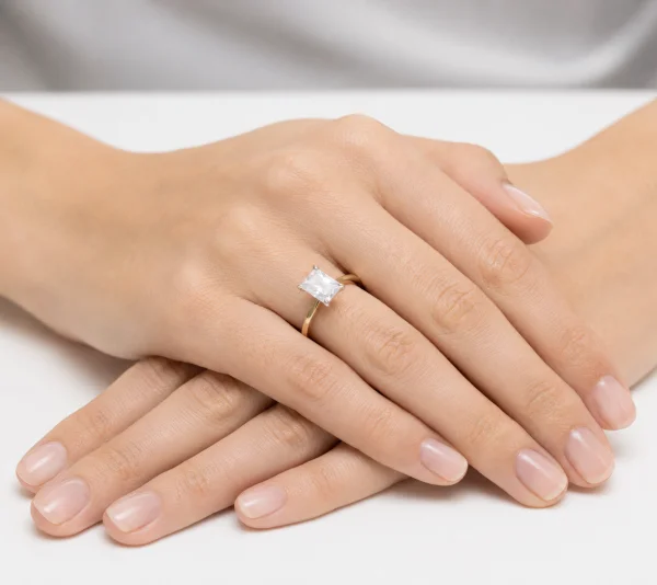 Geltono aukso sužadėtuvių žiedas su Emerald deimantu (Lab Grown 1.00 ct) ant merginos rankos