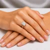 Sužadėtuvių žiedas su Emerald deimantu (Lab Grown 2.00 ct) geltonas auksas ant merginos rankos